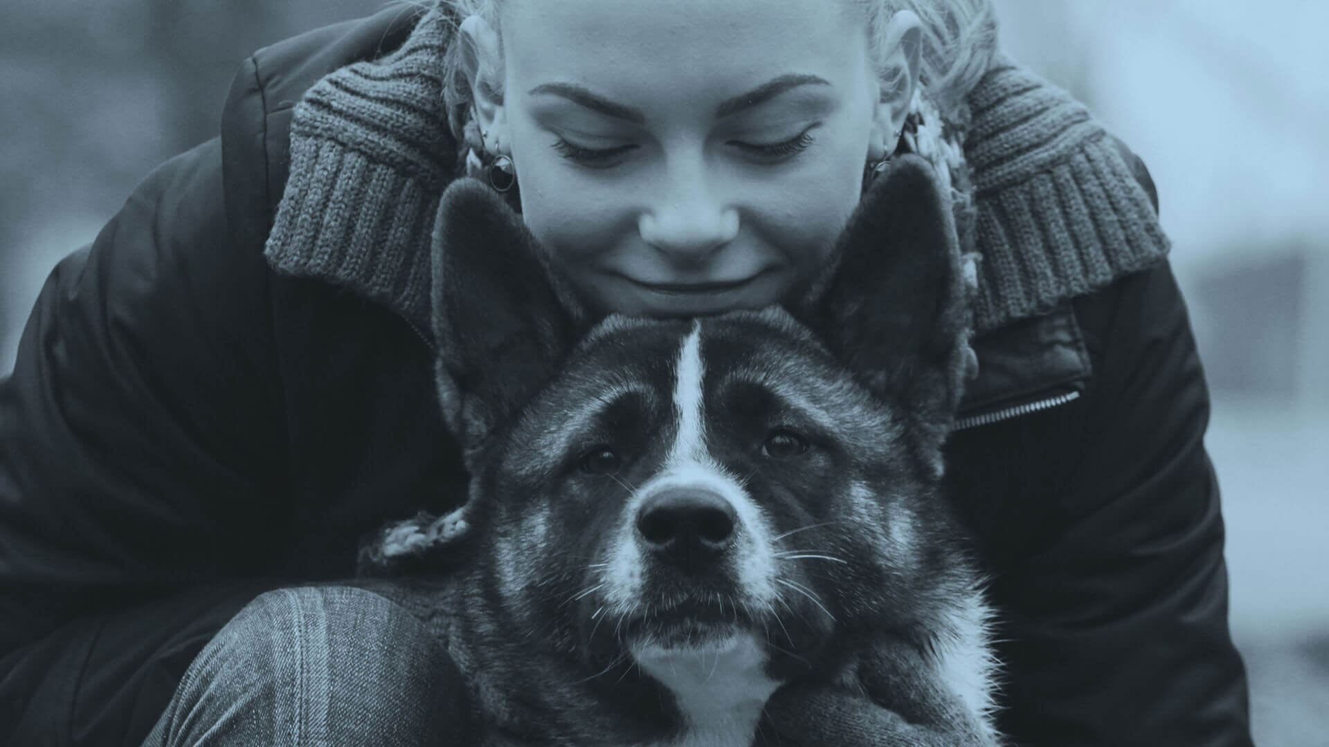 Happy female dog owner lovingly looking at her dog