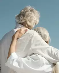 Abrazo entre dos personas mayores