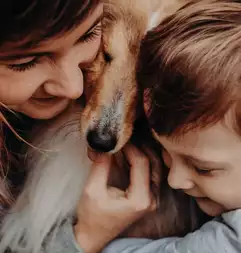 Mujer y niña abrazando a un perro